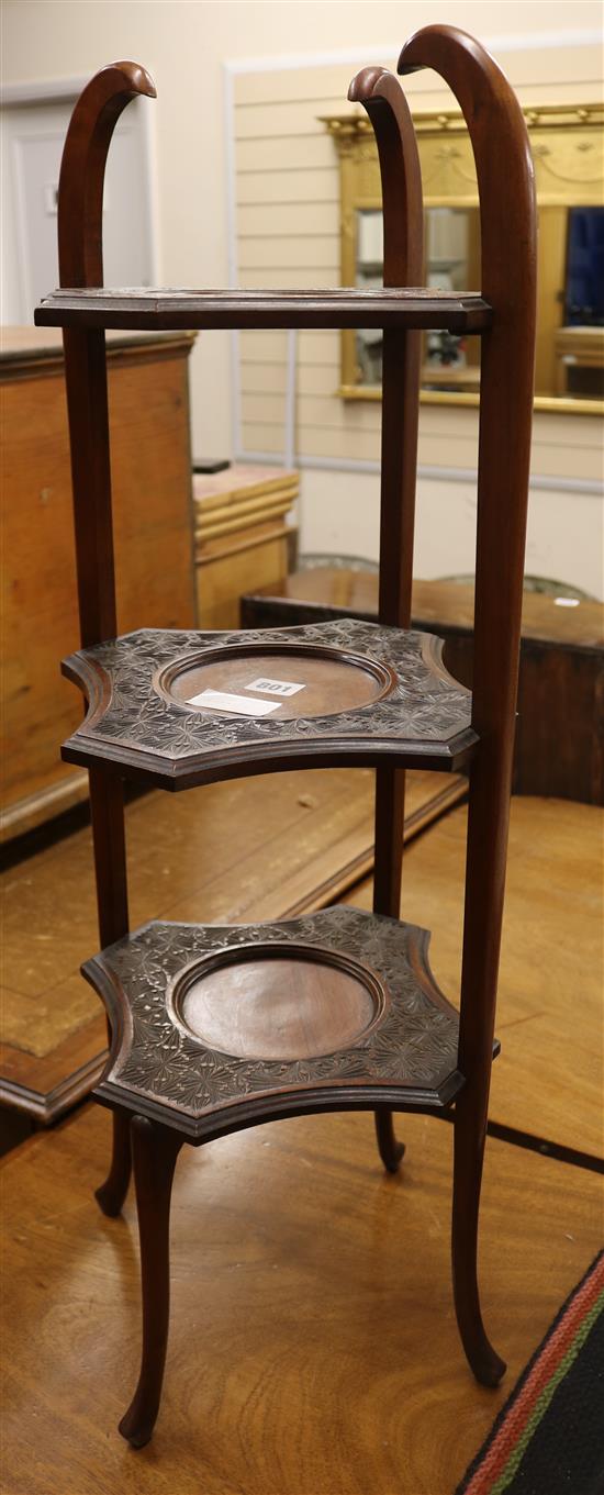 An Edwardian carved three tier folding cake stand, 81cm high